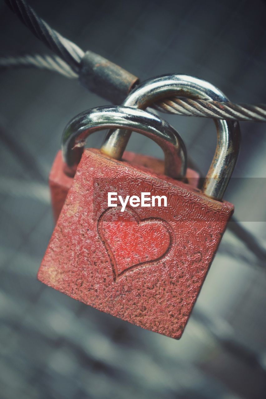 CLOSE-UP OF PADLOCKS ON HEART SHAPE METAL