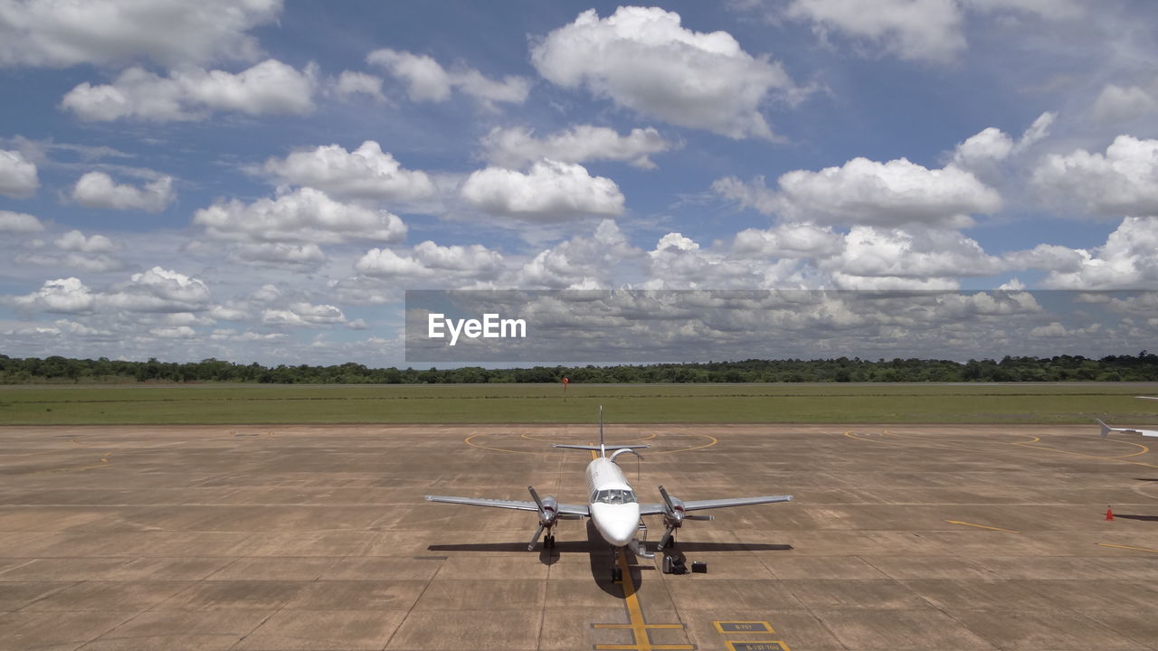 Airplane on runway against sky