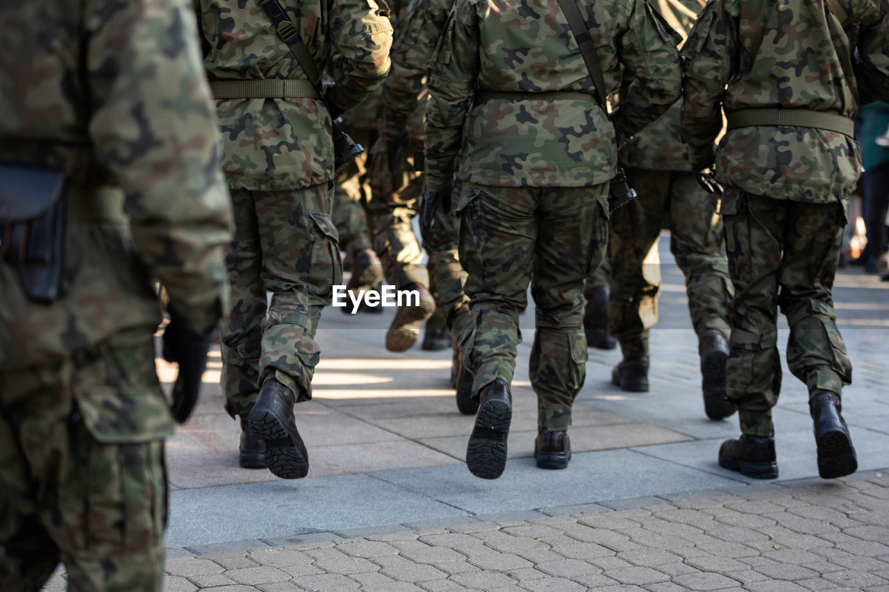 Rear view of marching soldiers in full uniform.