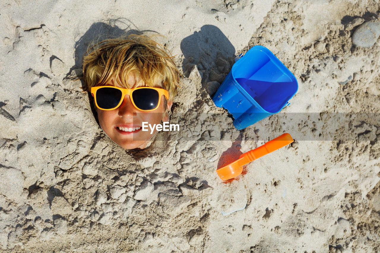 high angle view of woman wearing sunglasses on sand at beach