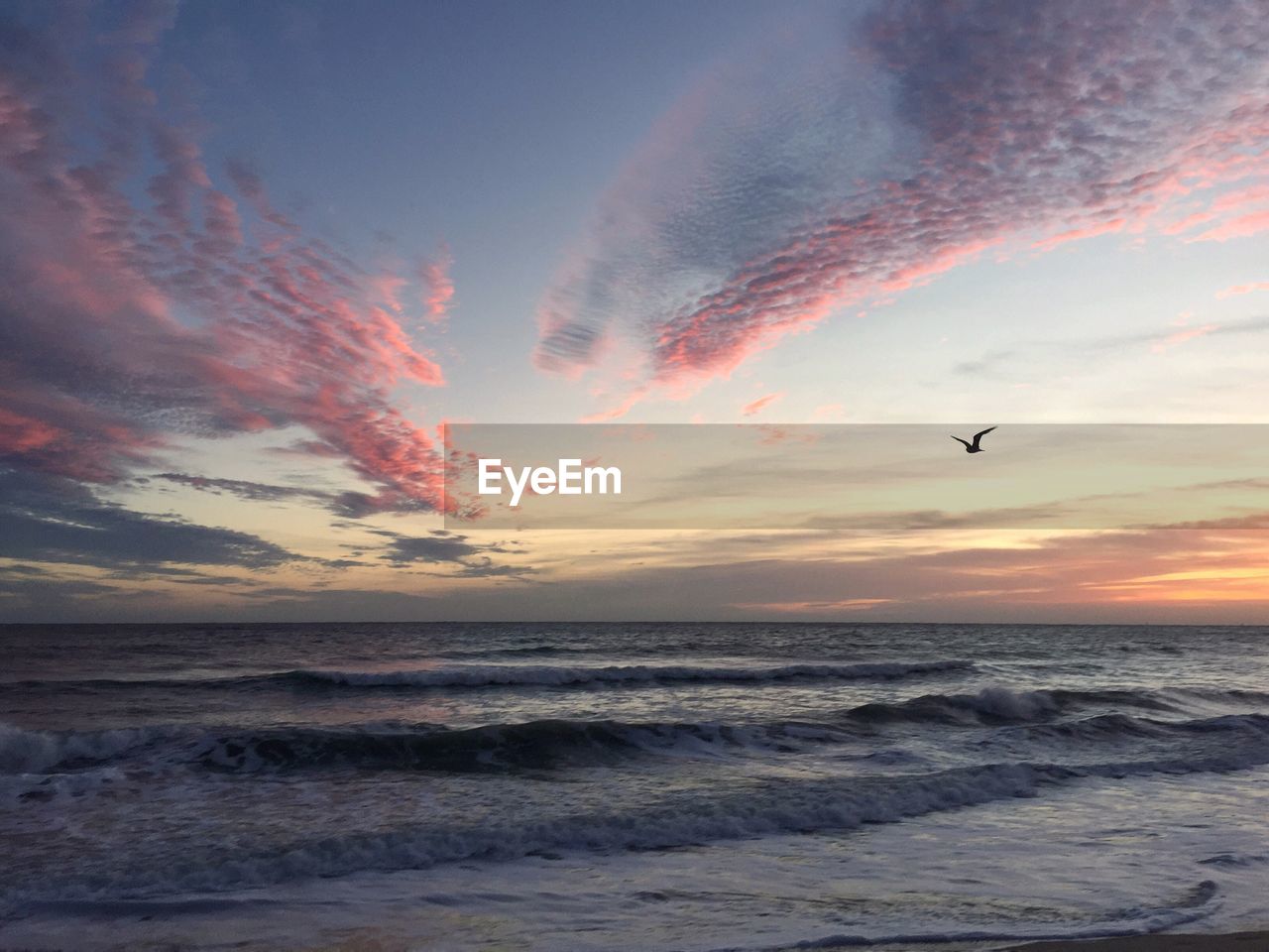 SCENIC VIEW OF BEACH AGAINST SKY AT SUNSET