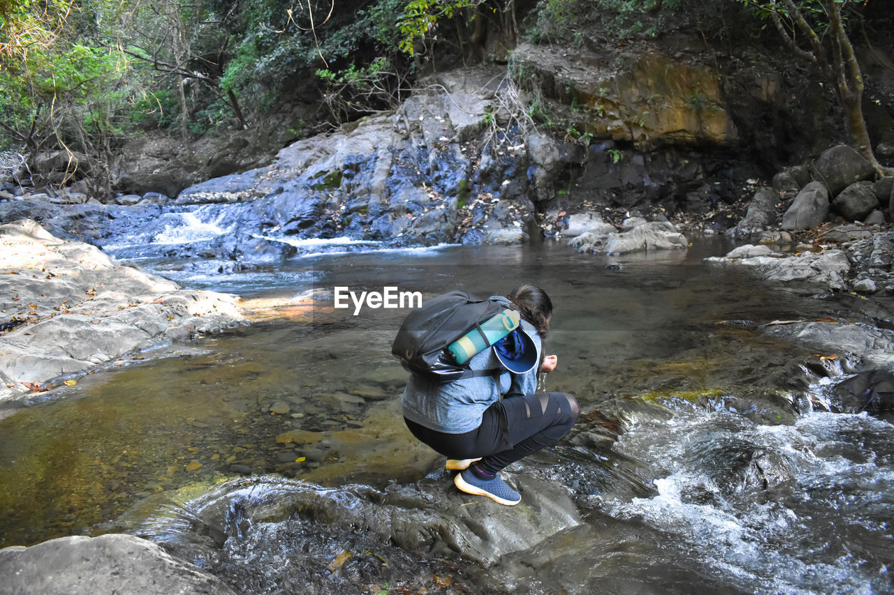 High angle view of woman in stream flowing through rocks