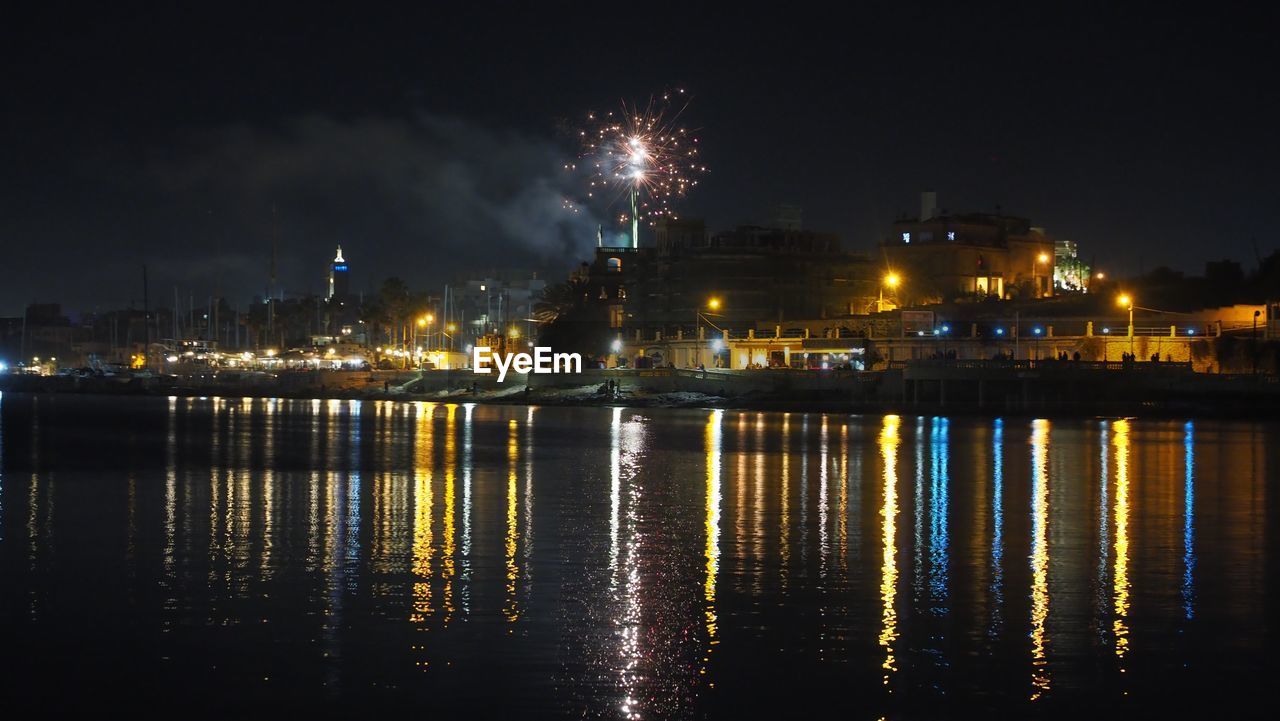 Fireworks display, illuminated city and light reflectio non water -  nye manoel island malta