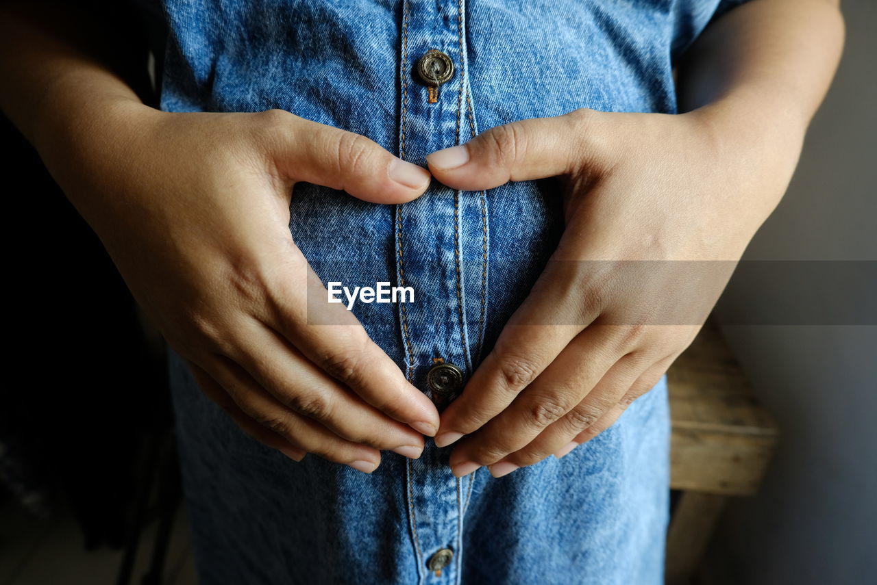 Midsection of pregnant woman touching her stomach