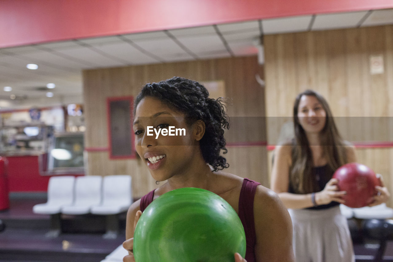 A young woman bowling.