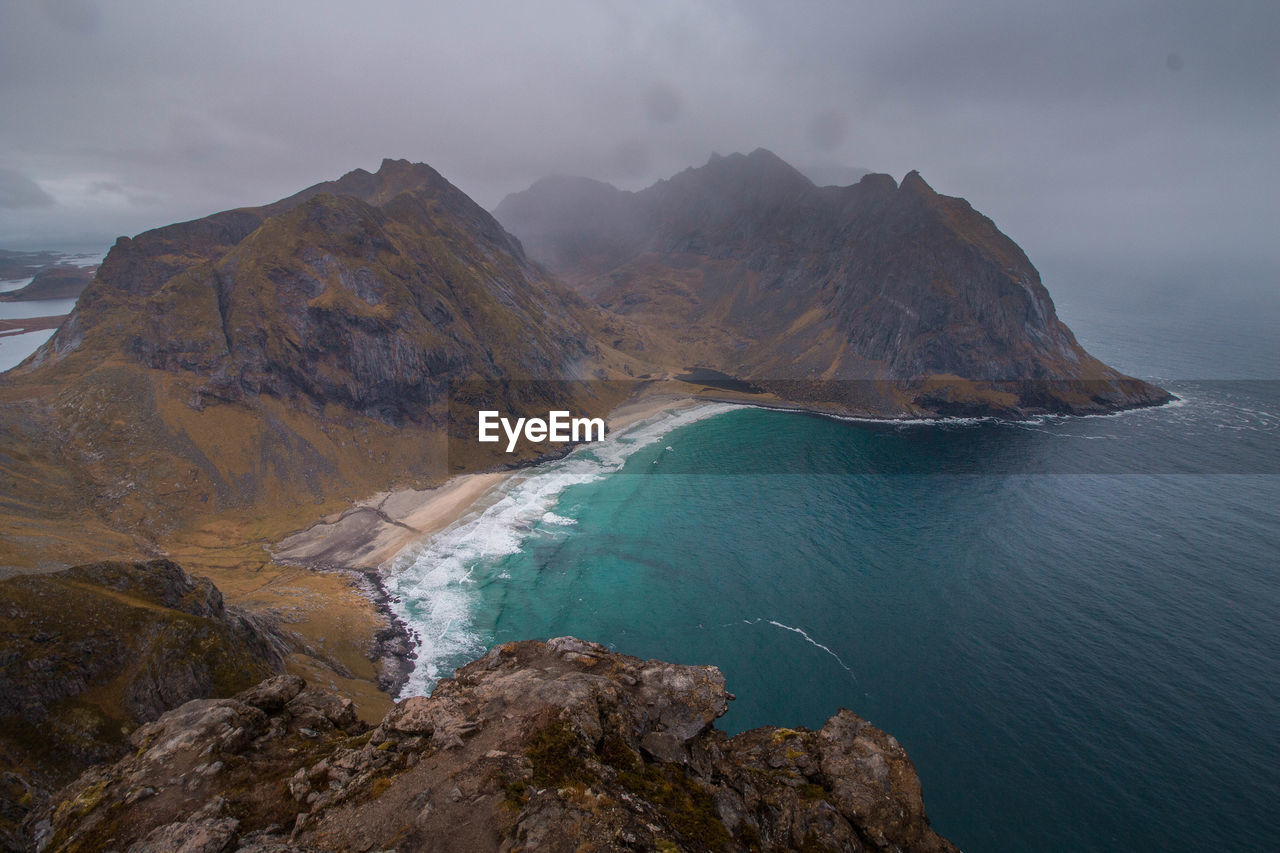 Scenic view of sea and mountains against sky