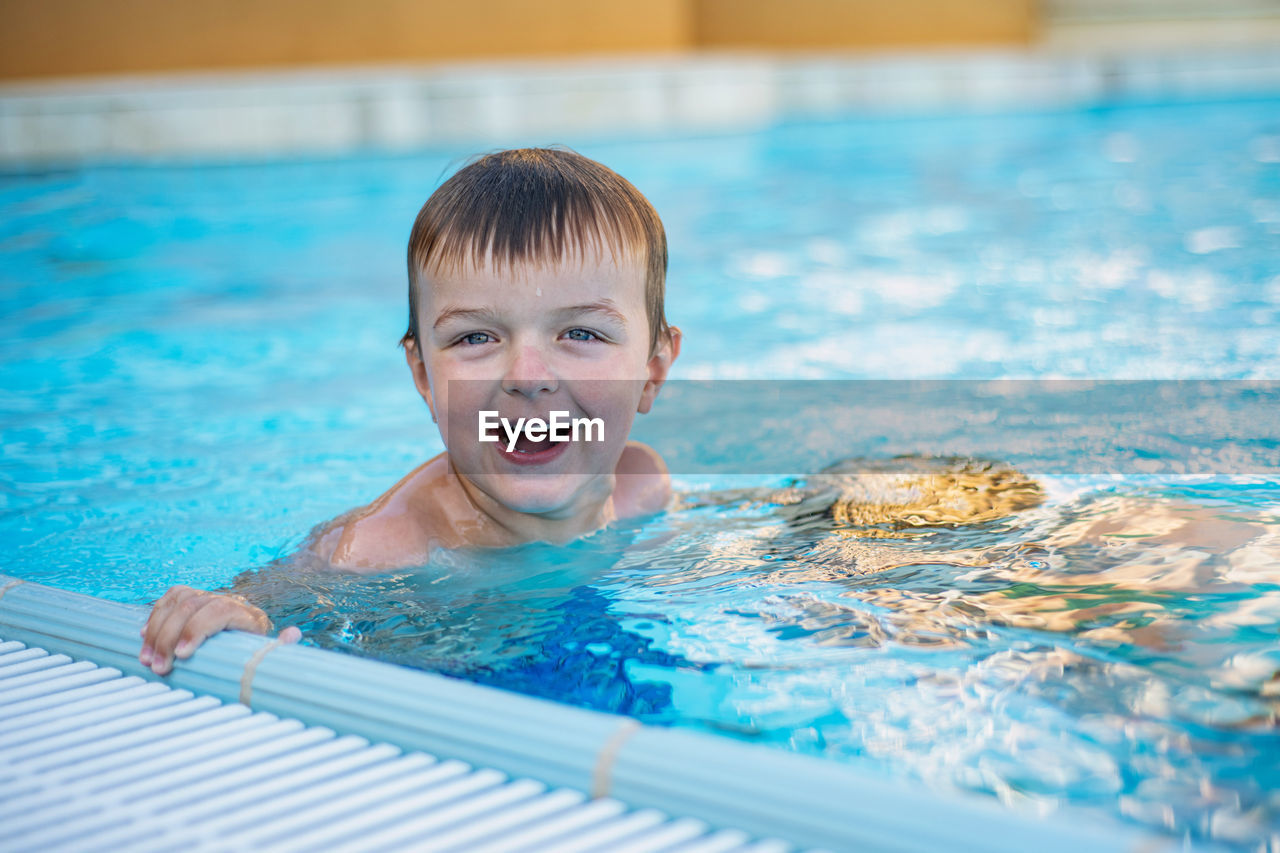 Portrait of cute boy in swimming pool