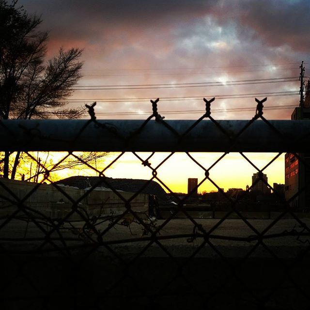 VIEW OF CHAINLINK FENCE AT SUNSET