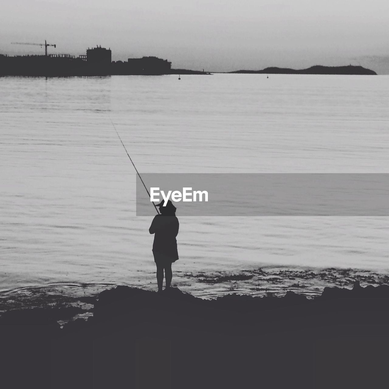 Silhouette of woman fishing