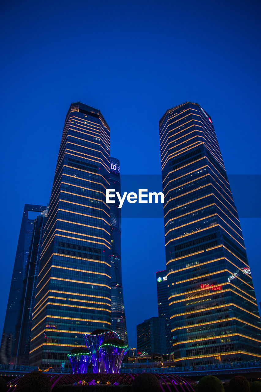 Low angle view of modern buildings against blue sky