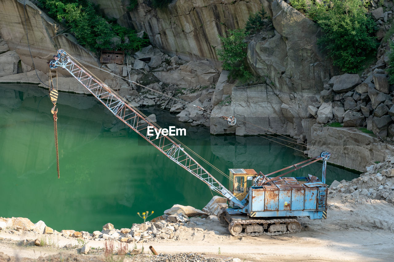 Mining in the granite quarry. working mining machine - old crane. mining industry.