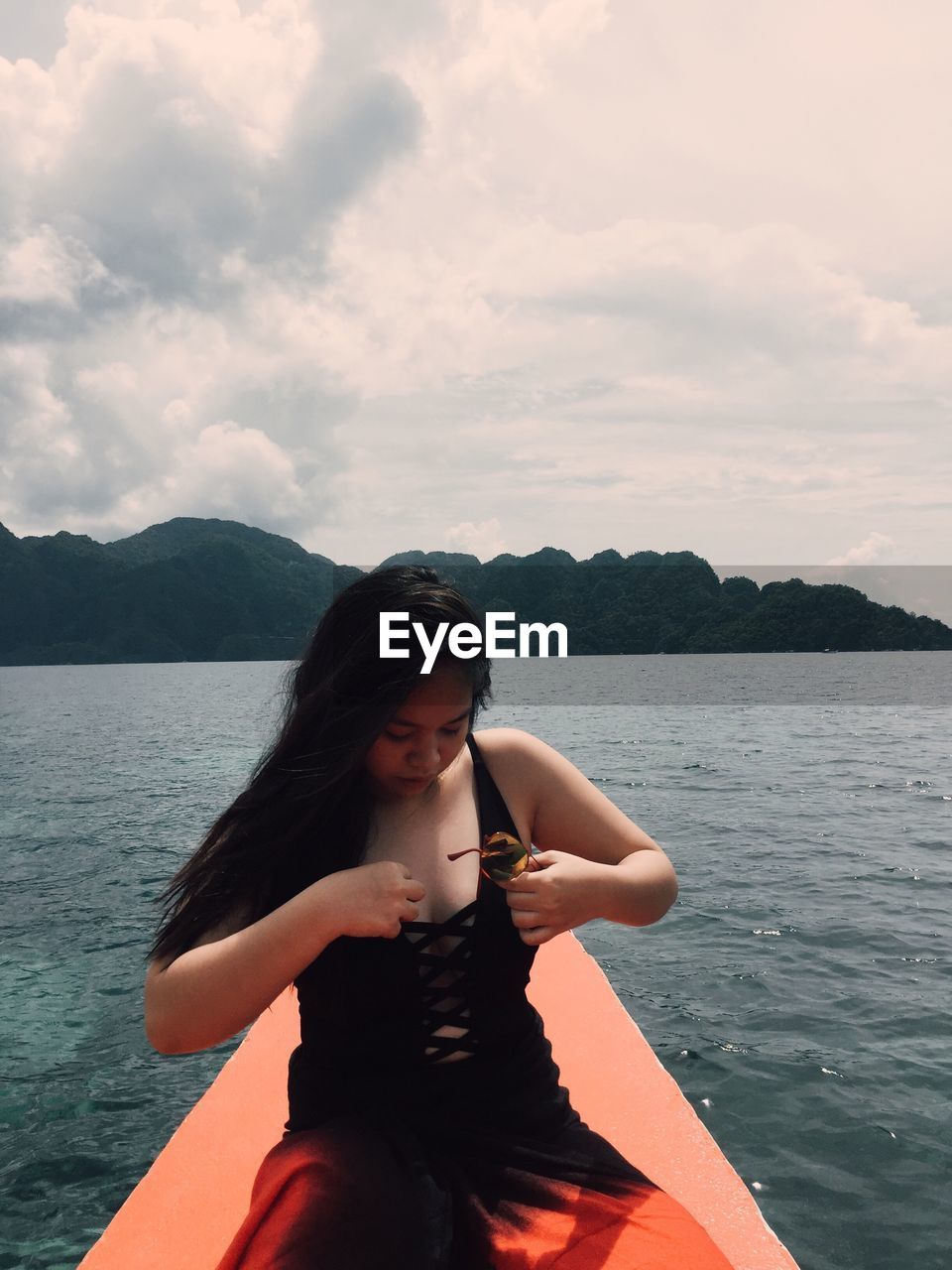 Young woman sitting on boat over sea