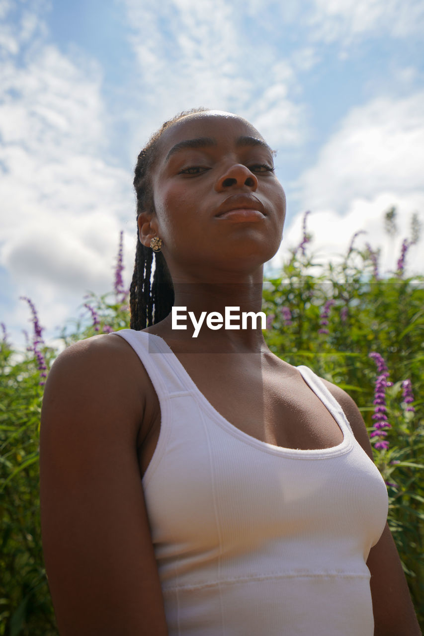 portrait of young woman looking away while standing outdoors