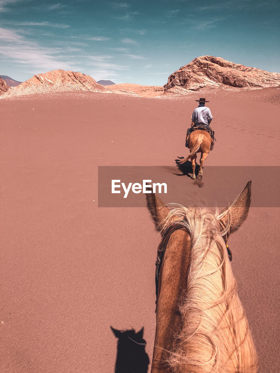 First person view of a young male horseback riding through desert