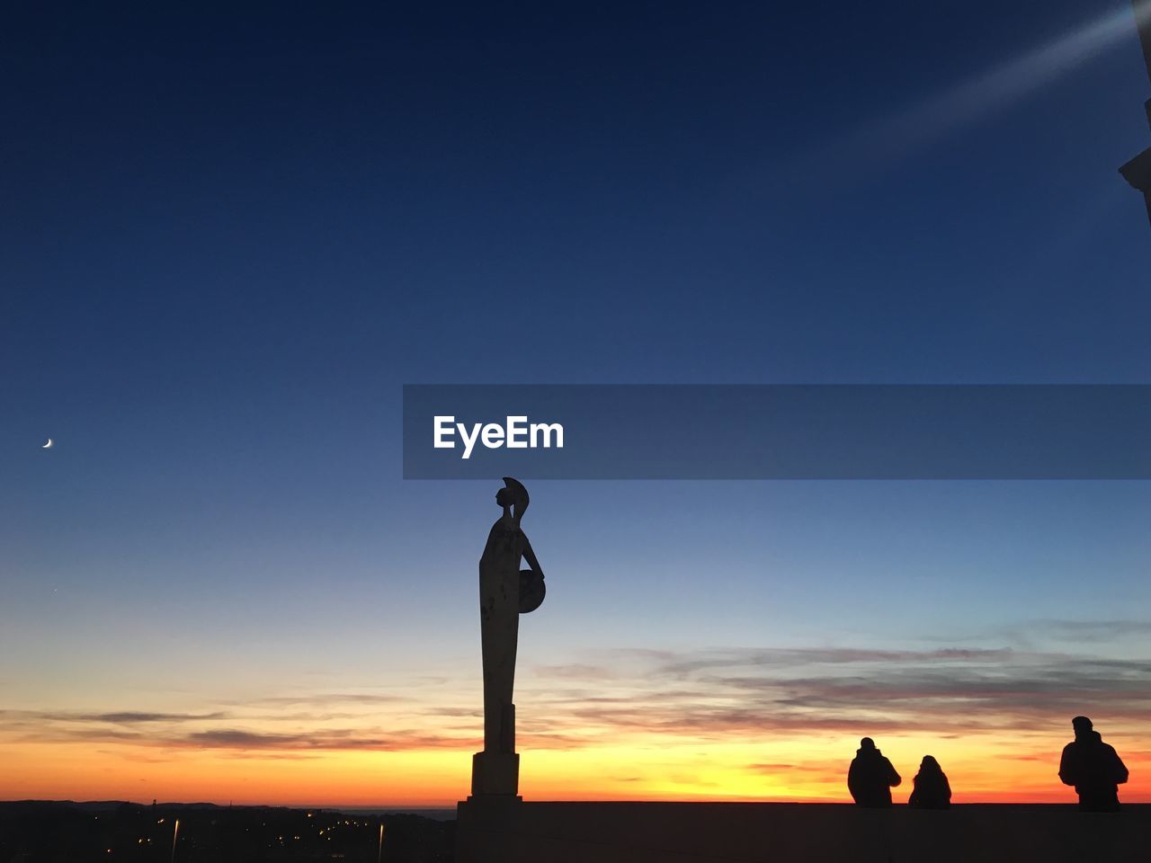 SILHOUETTE MAN STANDING AGAINST BLUE SKY