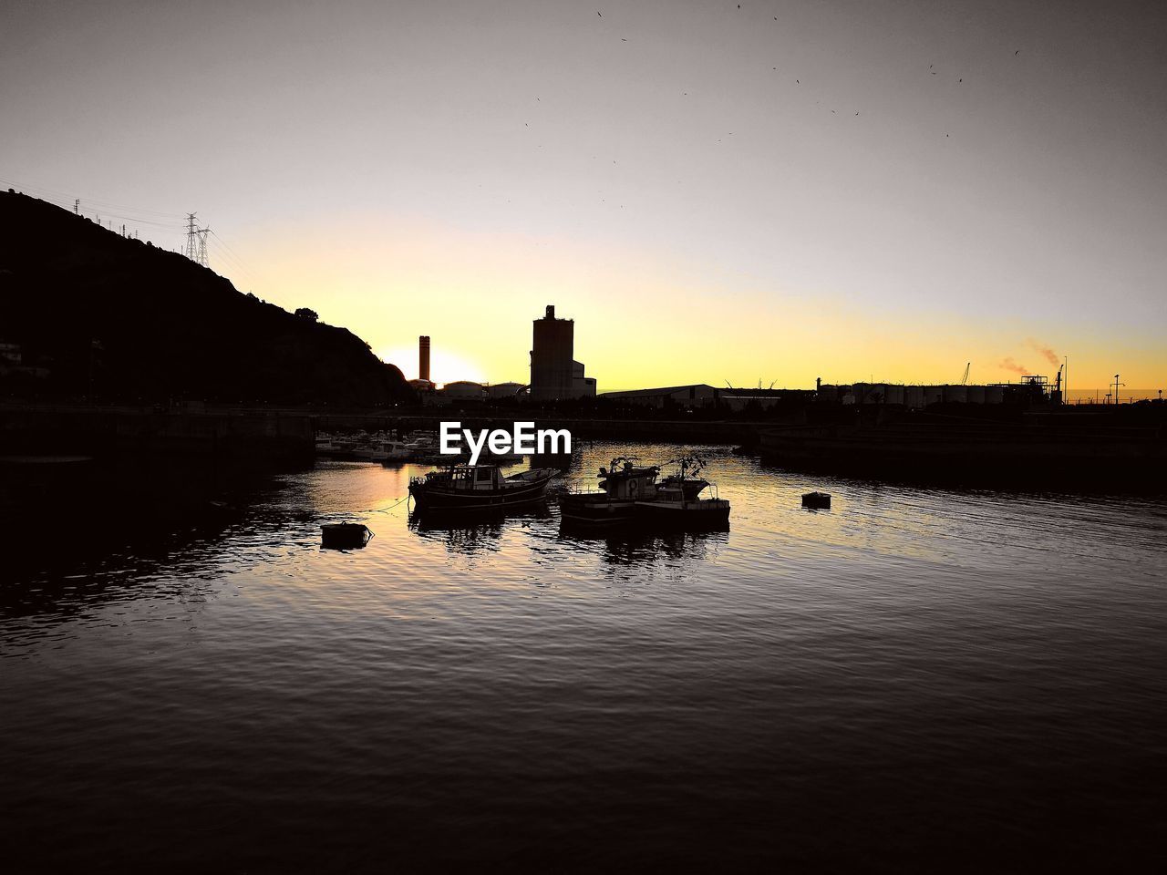 BOATS IN RIVER AT SUNSET