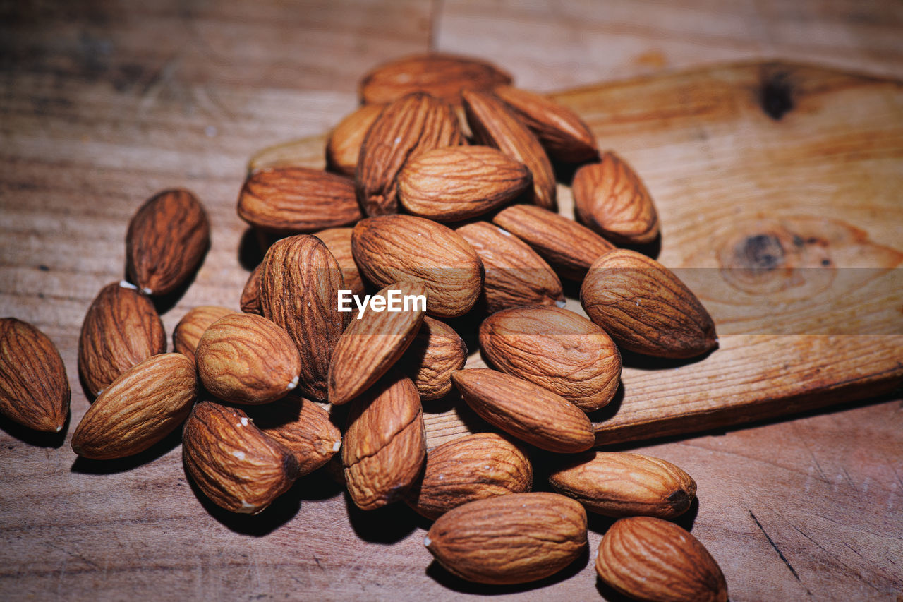 food and drink, food, nuts & seeds, produce, nut - food, nut, wellbeing, indoors, healthy eating, freshness, brown, wood, almond, large group of objects, still life, table, close-up, no people, abundance, plant, fruit