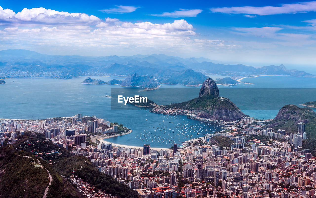 High angle view of sea and cityscape against sky