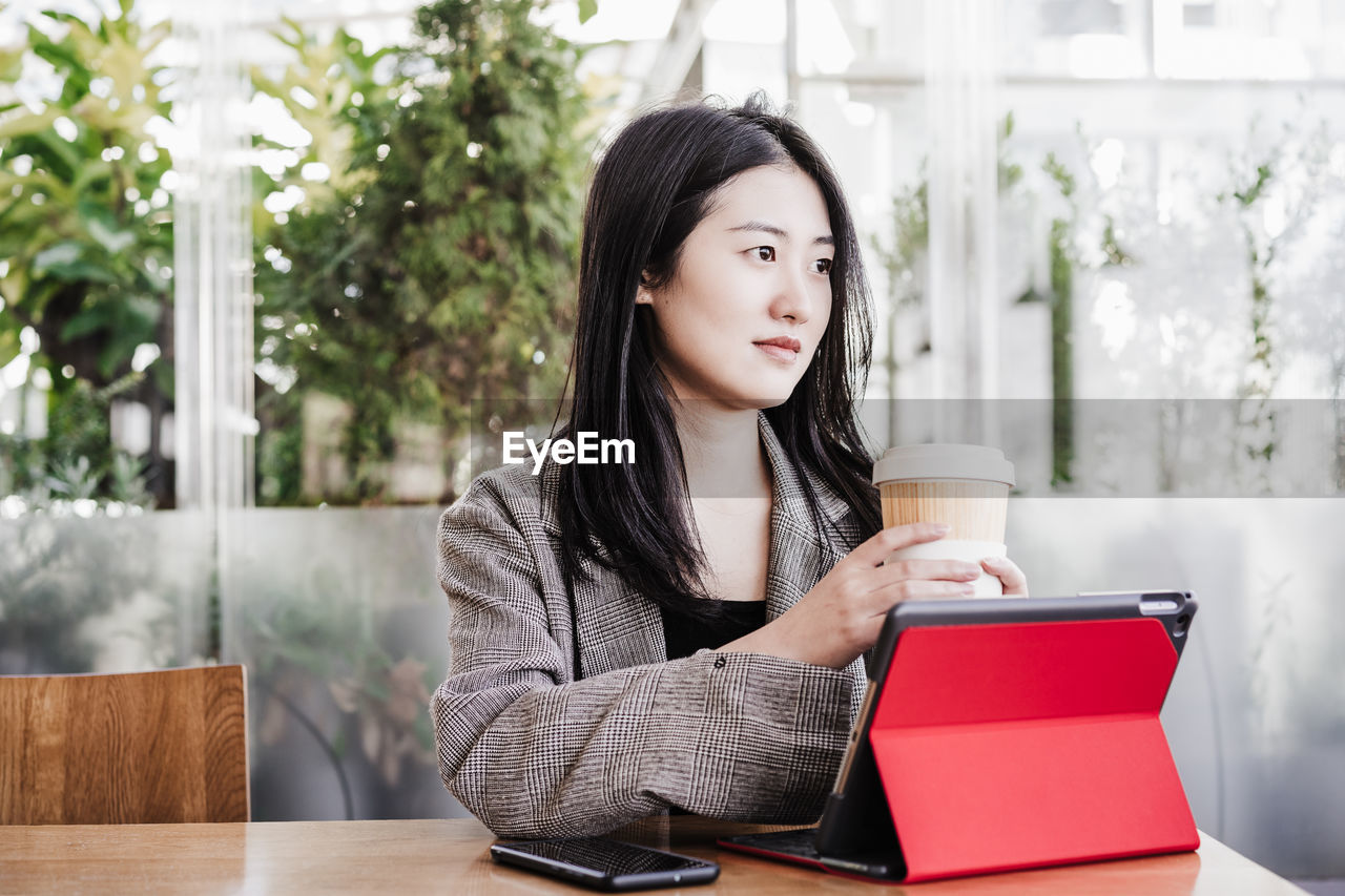 Professional chinese entrepreneur woman working on laptop in cafeteria. technology, lifestyle