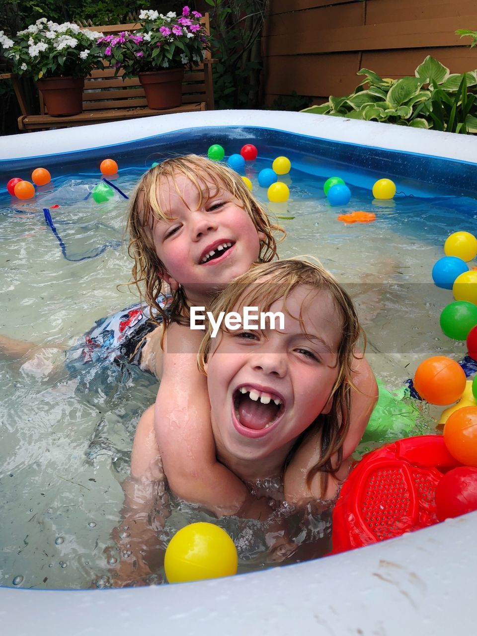 Portrait of sisters swimming in wading pool