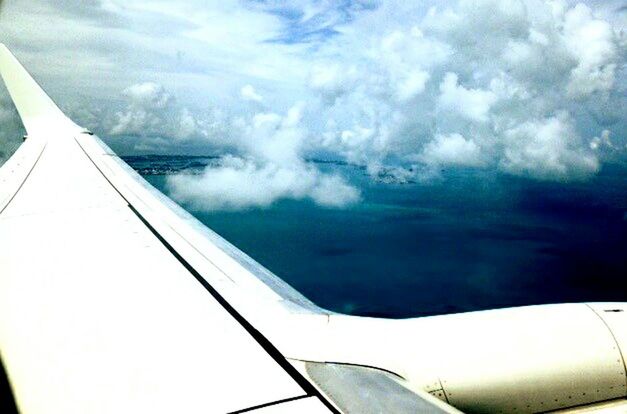 LOW ANGLE VIEW OF AIRPLANE WING OVER CLOUDS