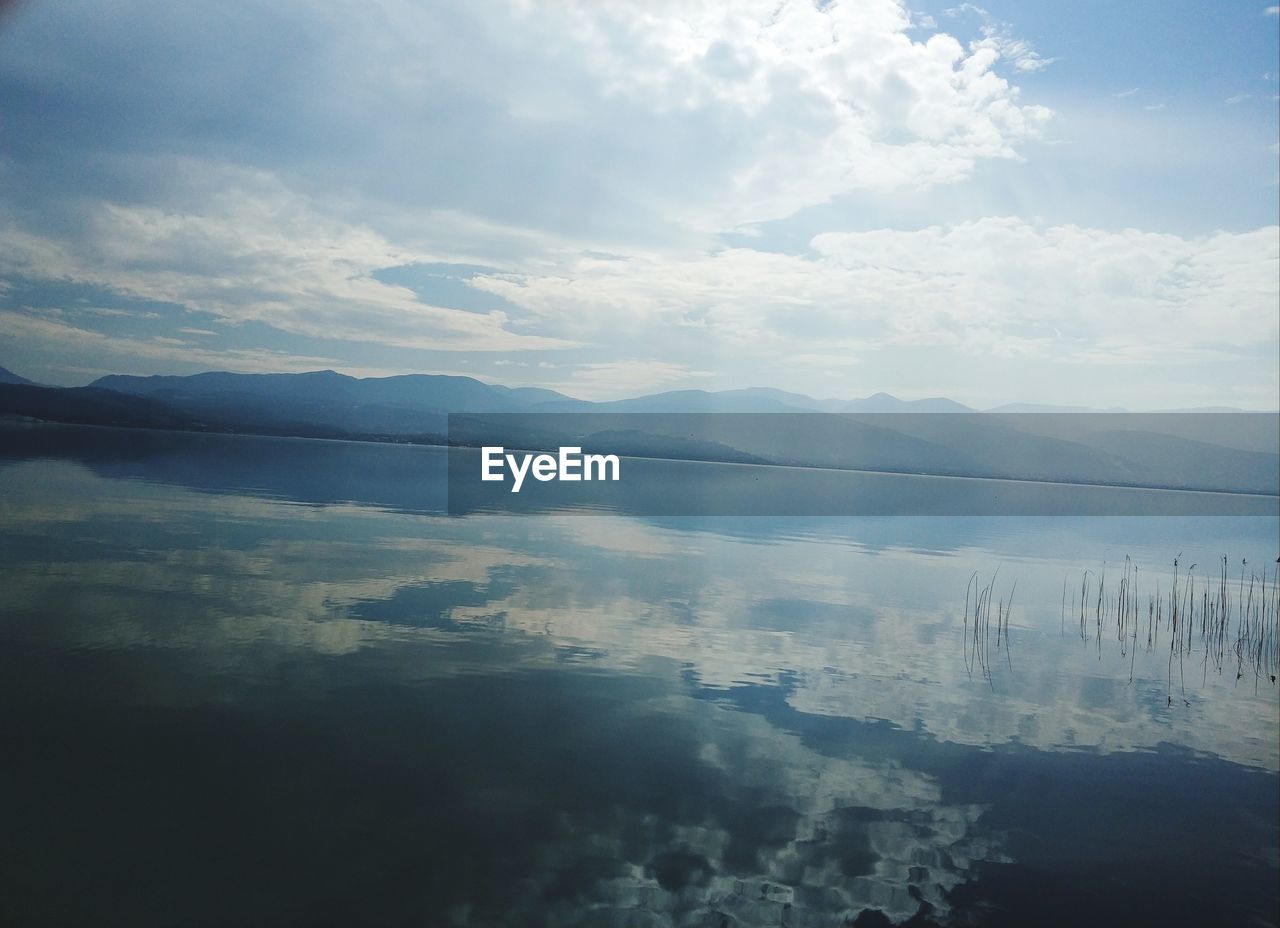 SCENIC VIEW OF LAKE BY MOUNTAIN AGAINST SKY