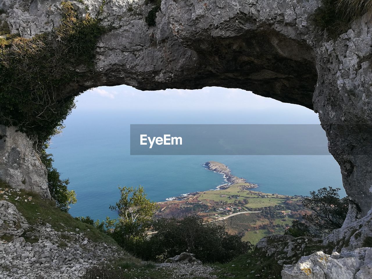 Scenic view of sea and mountains seen through arch