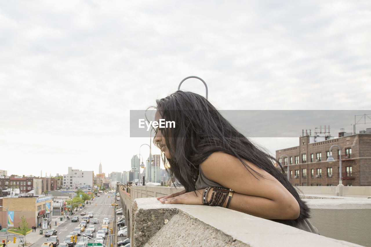 Young woman leaning on a bridge in queens, new york