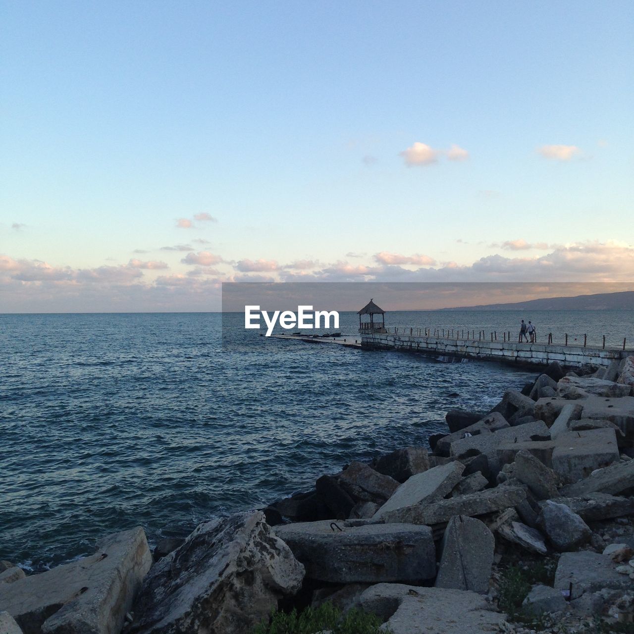 View of calm blue sea against cloudy sky