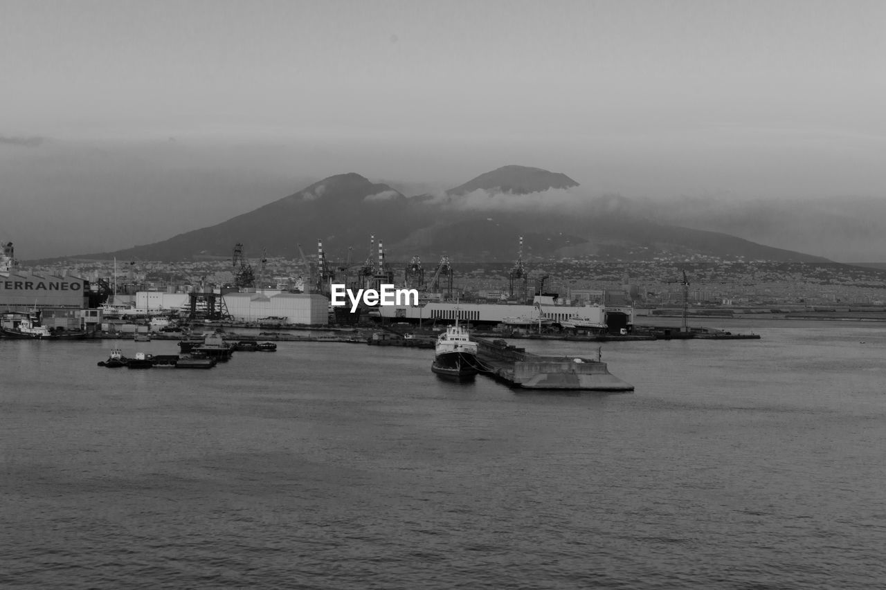 Commercial dock by mt vesuvius against sky