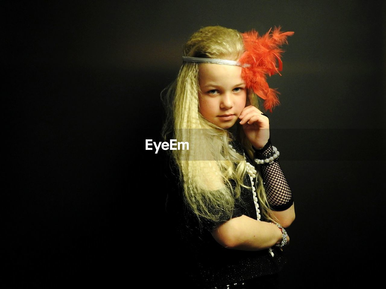 Portrait of girl wearing headdress against black background