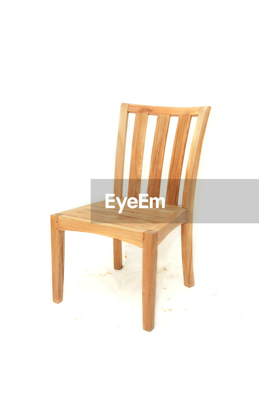 CLOSE-UP OF EMPTY CHAIR AGAINST WHITE BACKGROUND