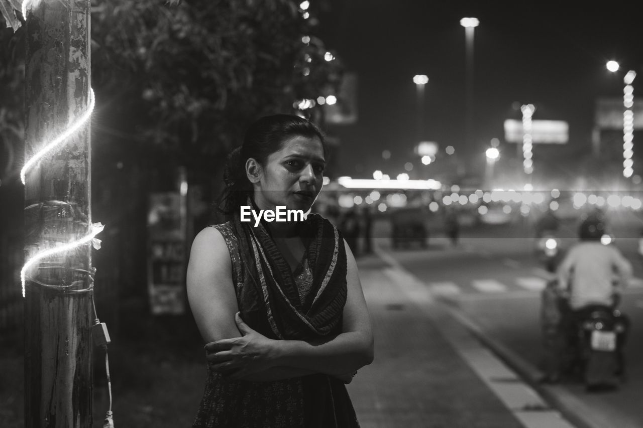 PORTRAIT OF WOMAN STANDING AT NIGHT