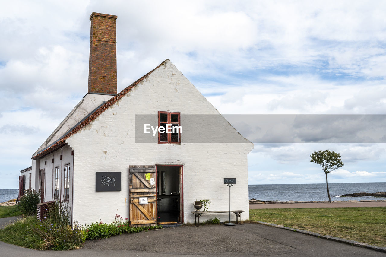 architecture, built structure, building exterior, cloud, building, sky, nature, house, rural area, water, cottage, landscape, home, no people, estate, sea, rural scene, land, place of worship, day, outdoors, residential district, road, beach, city, grass, plant, farmhouse, tower, street, travel destinations, entrance, scenics - nature, window, residential area, wood, facade, environment