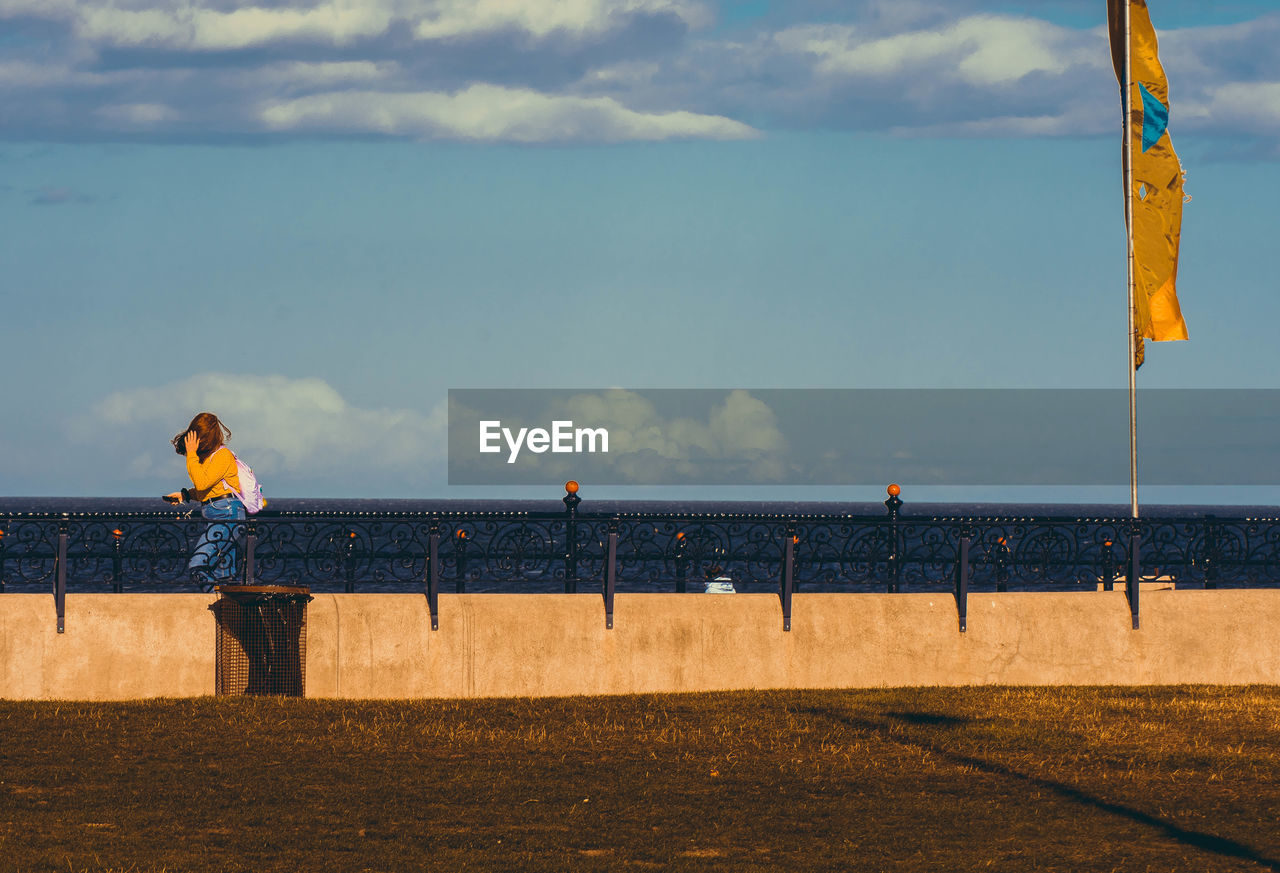 MAN ON RAILING AGAINST SEA