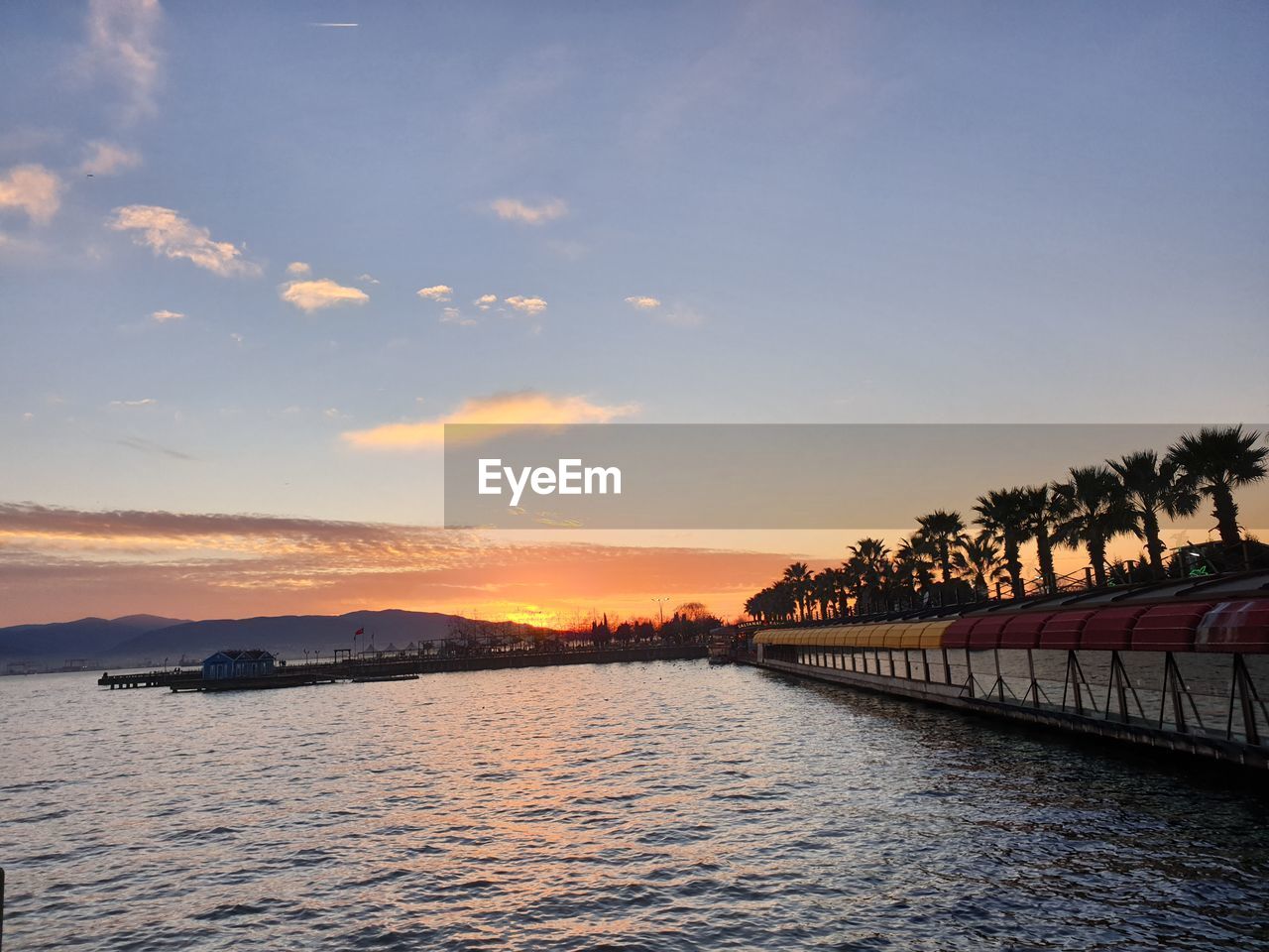 SCENIC VIEW OF RIVER BY TREES AGAINST SKY DURING SUNSET