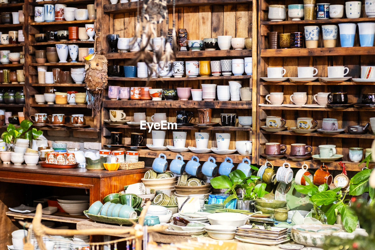 Small store with many pottery ceramic standing on shelves.