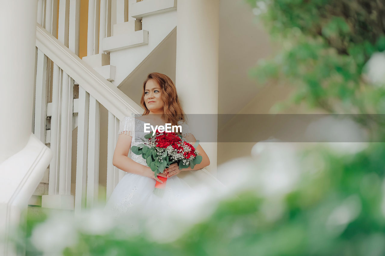 Woman sitting on plant at home