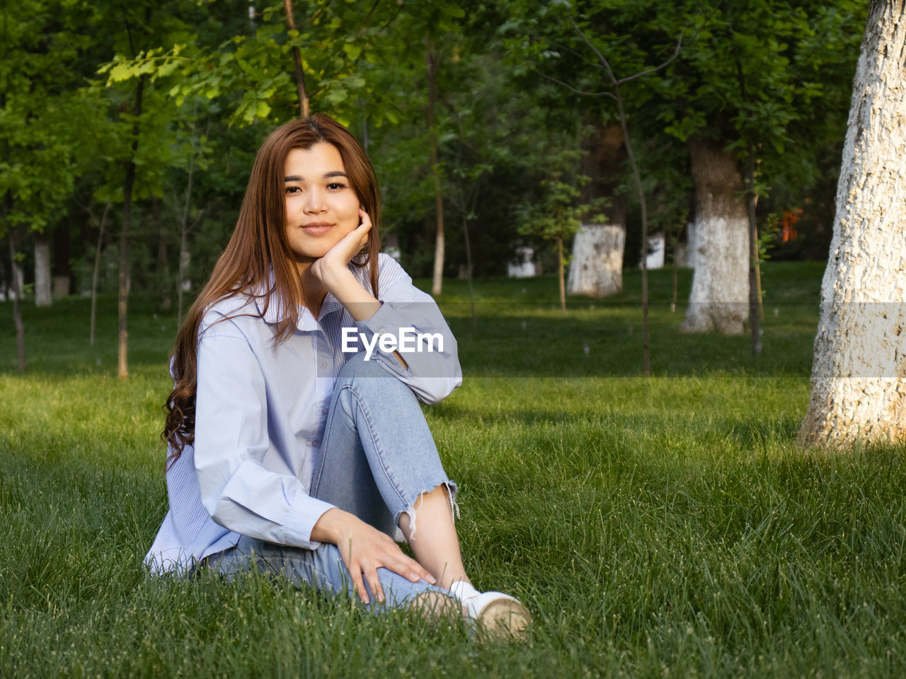 Portrait of young woman sitting on field