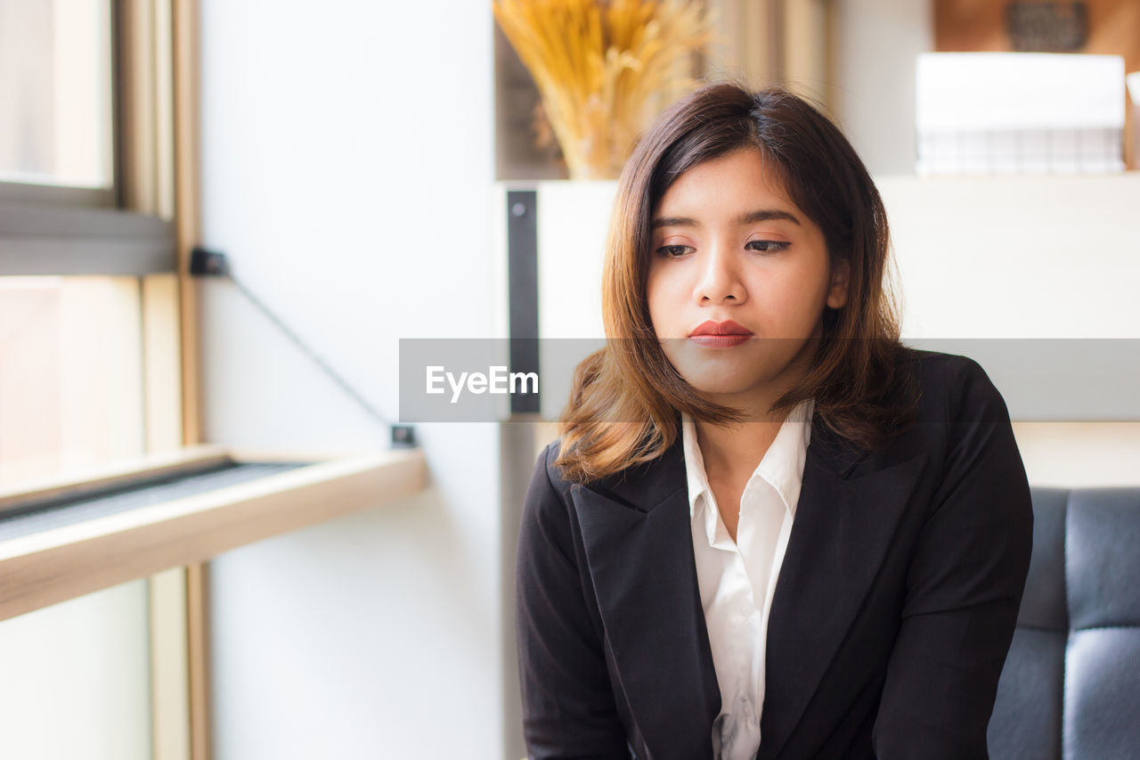 Businesswoman looking away while sitting on couch