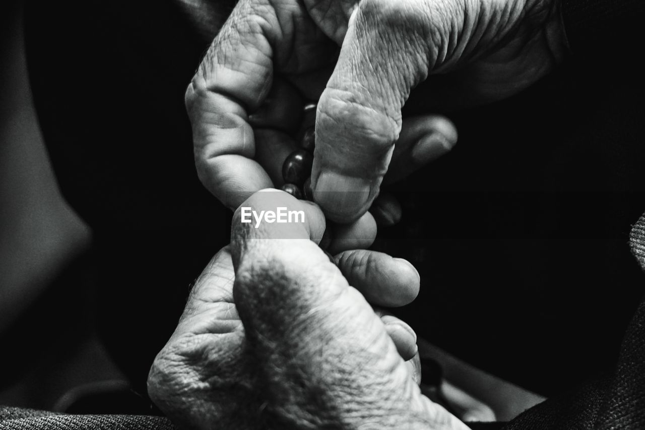 Close-up of hands holding praying beads