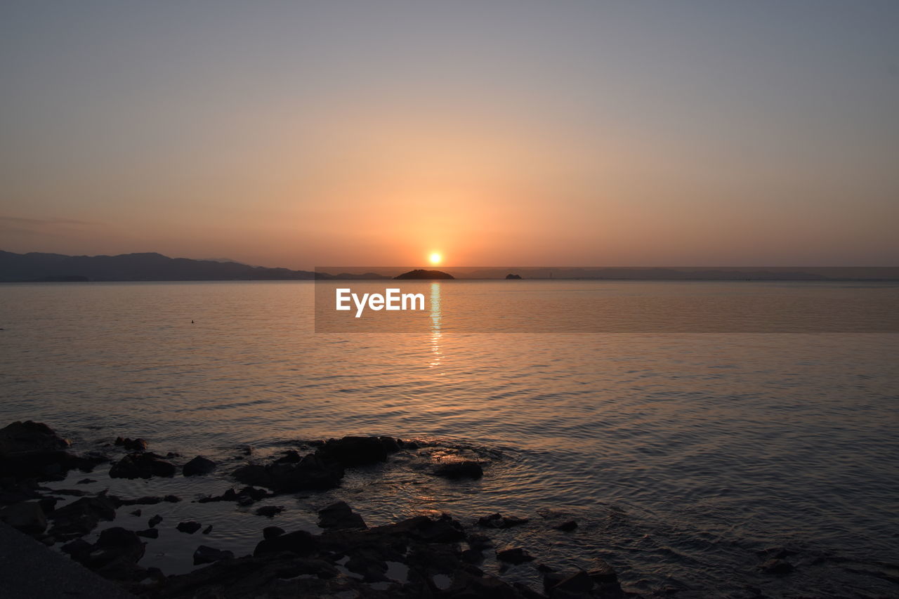 SCENIC VIEW OF SEA AT SUNSET