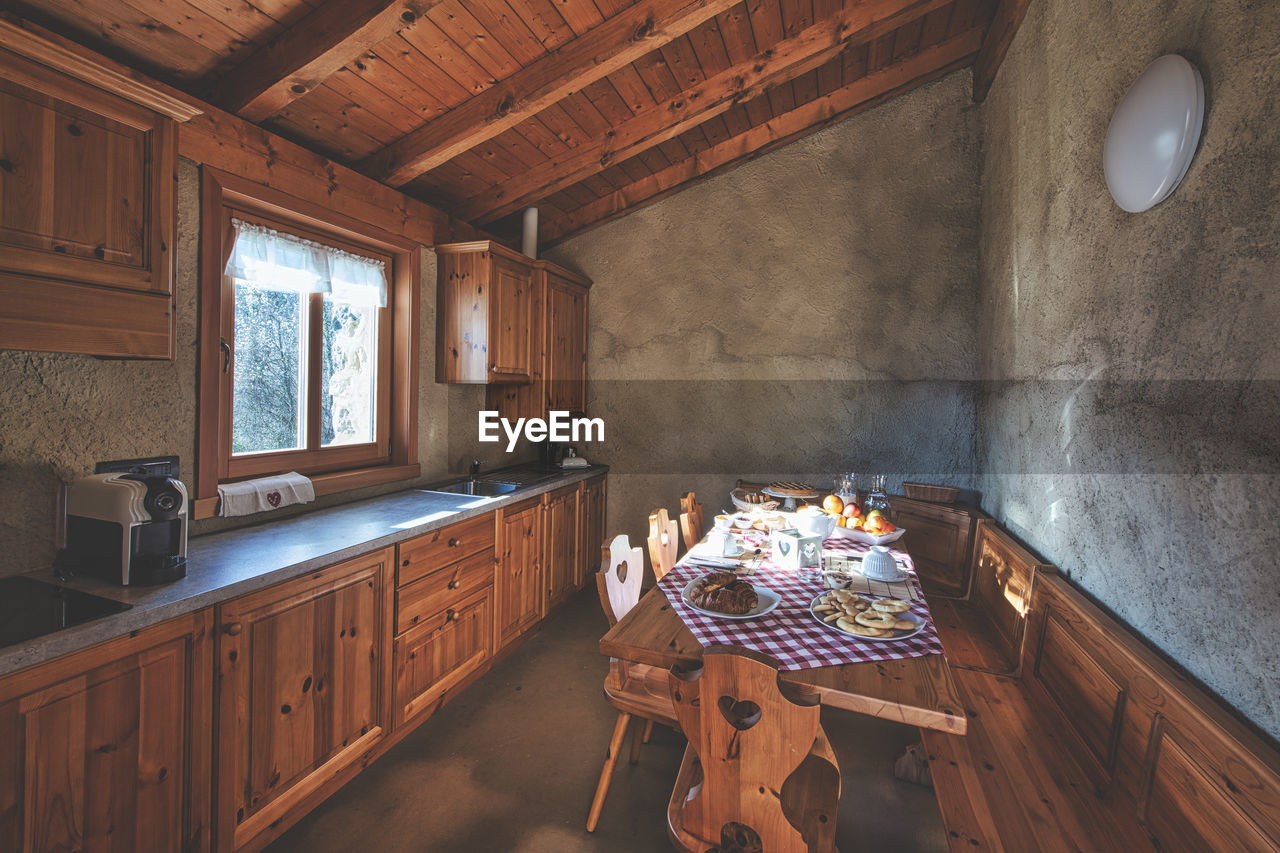 indoors, wood, room, architecture, window, estate, home interior, domestic room, cottage, built structure, home, farmhouse, flooring, no people, table, building, furniture, house, rustic, interior design, log cabin, floor, ceiling, wall - building feature, day, seat, nature