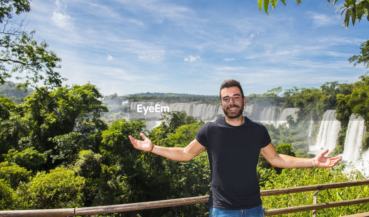 Young man posing in front of the iguacu waterfalls in argentina