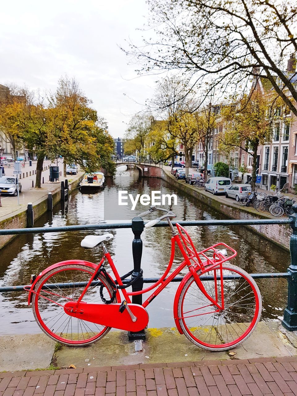 BICYCLE PARKED BY RIVER AGAINST SKY