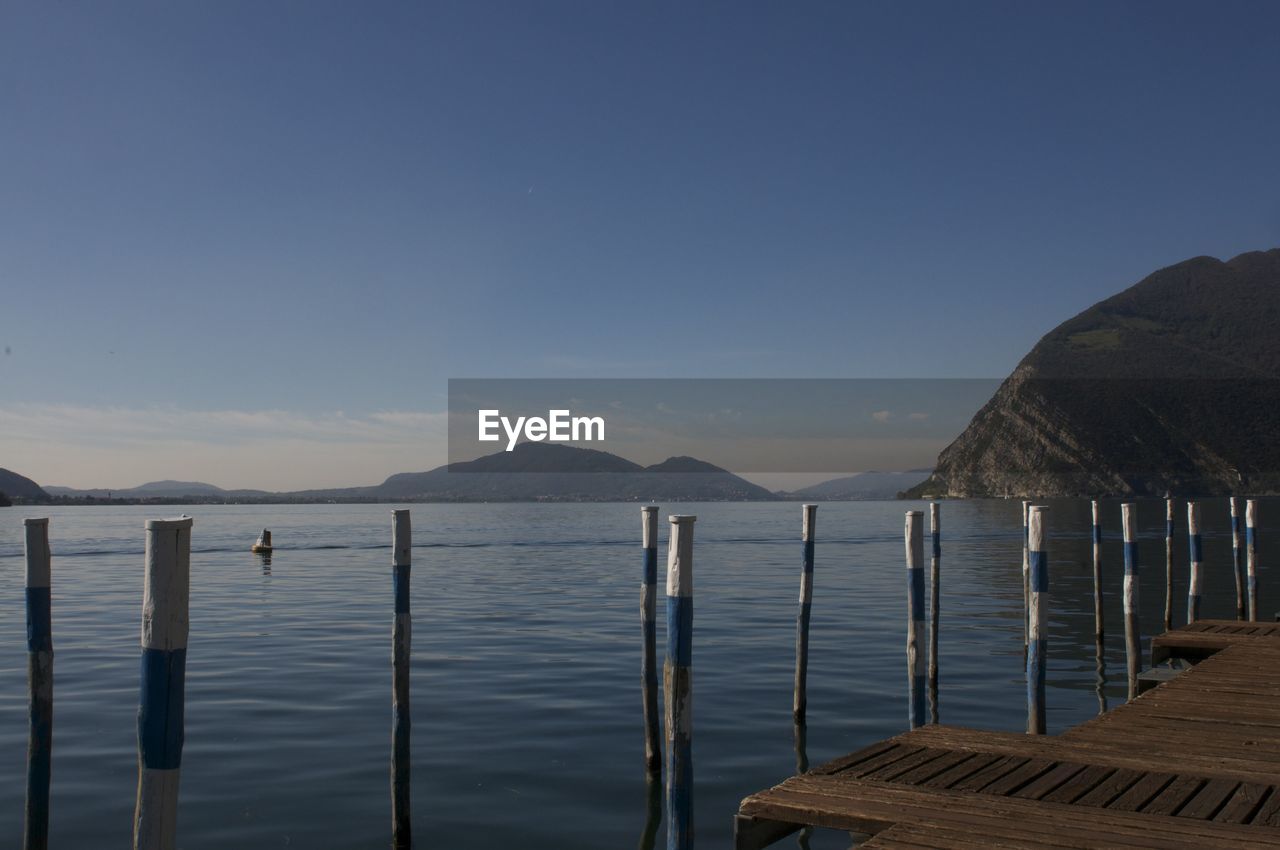 SCENIC VIEW OF SEA AND MOUNTAINS AGAINST CLEAR SKY