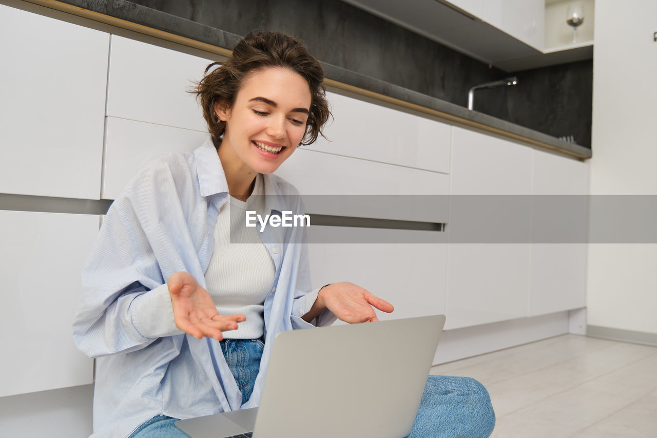 portrait of young businesswoman using digital tablet while standing in office