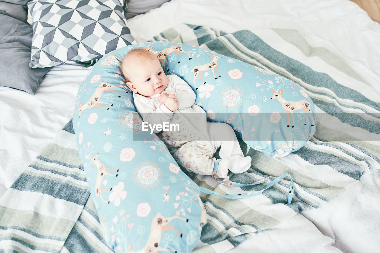 High angle view of baby girl lying on bed