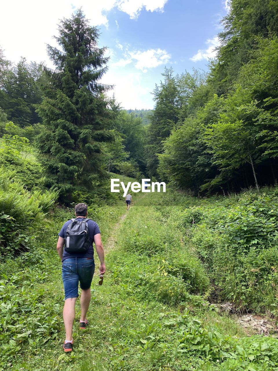 FULL LENGTH REAR VIEW OF WOMAN WALKING ON TRAIL