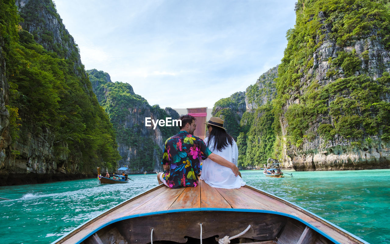 rear view of woman sitting on boat on lake